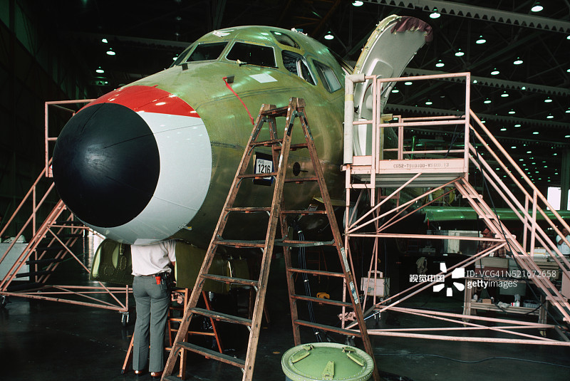 装配厂飞机机头旁的工人图片素材