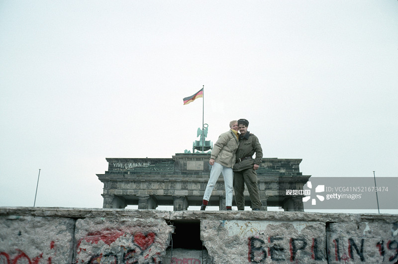 边防警卫与游客在柏林墙前合影图片素材