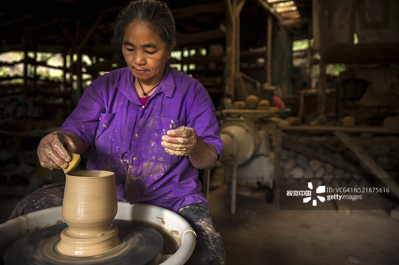女人制作泥塑松鸦图片素材