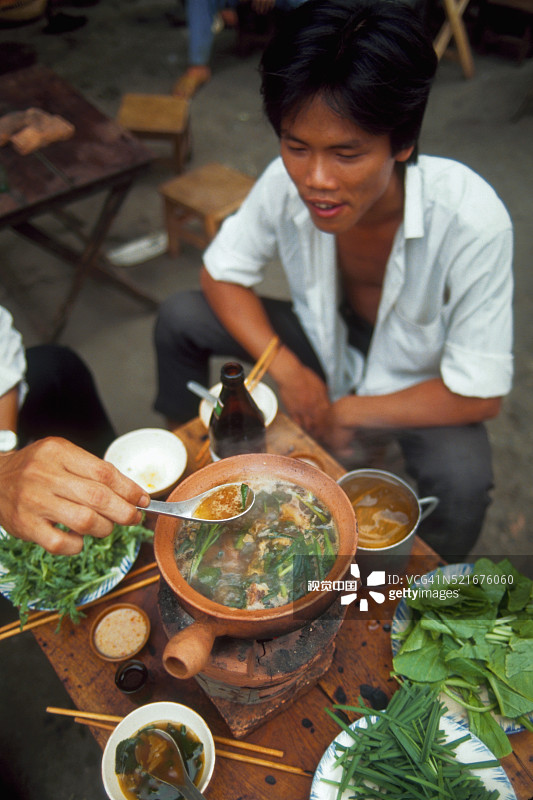 在越南粉摊位的年轻男人图片素材