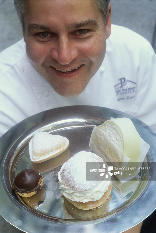 手捧甜点拼盘的糕点师图片素材