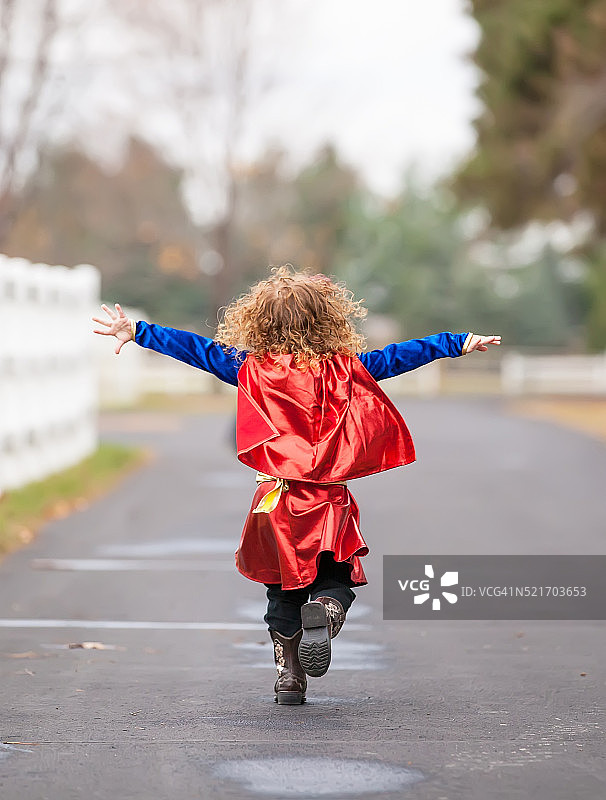 小女孩假装像超人一样飞翔图片素材