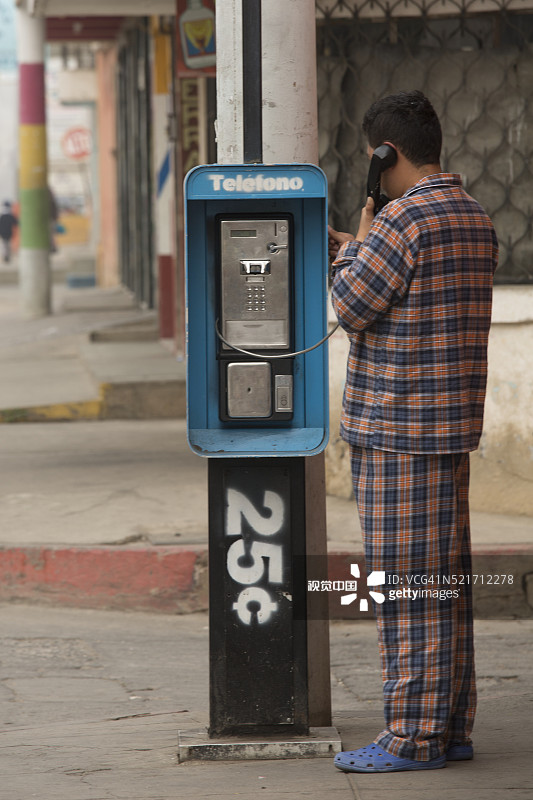 穿着睡衣在公用电话亭打电话图片素材