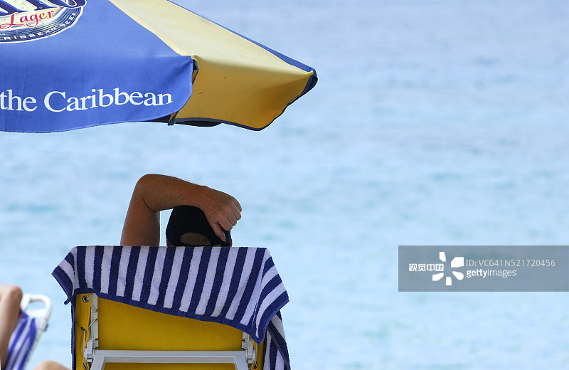 在加勒比海滩伞下休息的日光浴者图片素材
