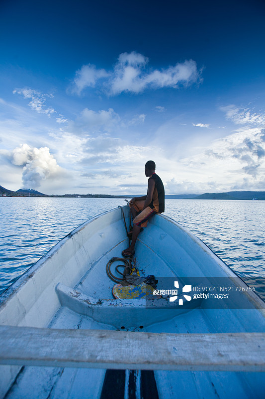 男子站在船头，卡维恩，巴布亚新几内亚图片素材