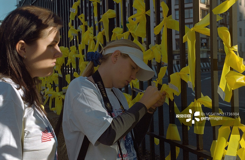 围栏上的黄色祈祷丝带图片素材