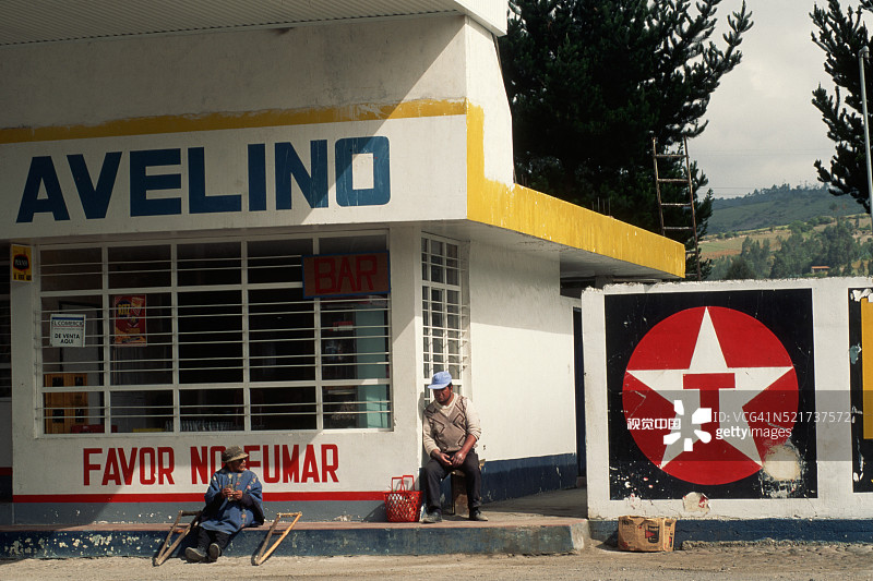 坐在德士古加油站外的人们图片素材