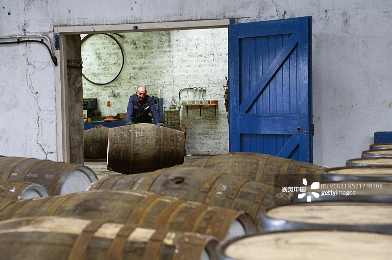 酿酒厂工人推滚酒桶图片素材