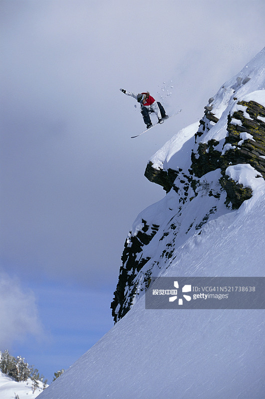 单板滑雪者飞跃悬崖图片素材