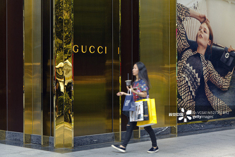 一位年轻女子走过中国台湾台北信义区的Gucci商店图片素材
