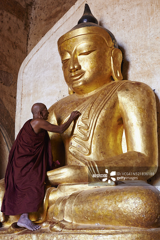 缅甸曼德勒省蒲甘阿难达寺触摸佛像的僧侣图片素材