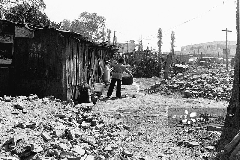 女人在棚屋外倒水图片素材