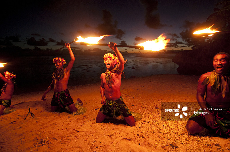 斐济珊瑚海岸日落时分海滩上的波利尼西亚毛利族火焰舞表演图片素材