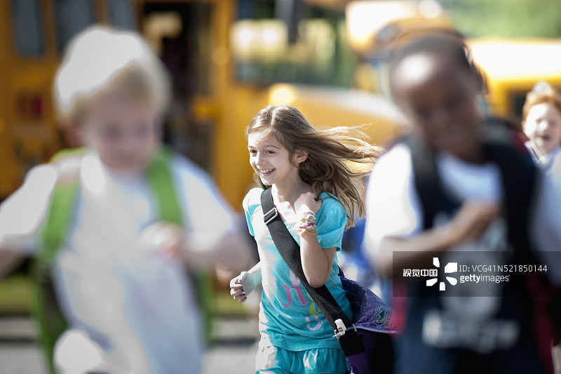 在校车附近奔跑的小学生图片素材