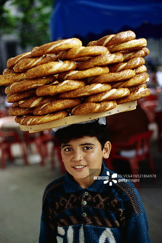 男孩拿着芝麻面包圈图片素材