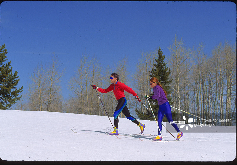 情侣在晴朗的一天越野滑雪图片素材