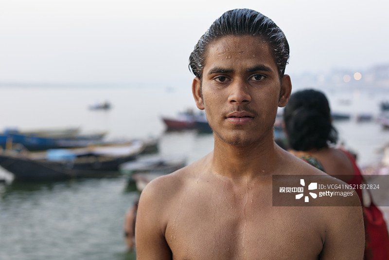 在印度瓦拉纳西恒河边沐浴的年轻男子图片素材