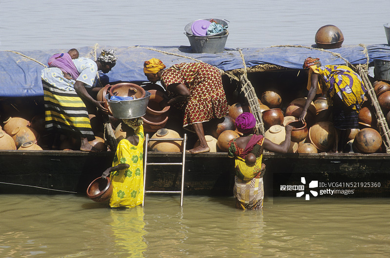 妇女在尼日尔河上从独木舟上卸下陶器图片素材