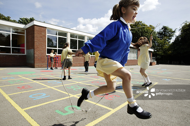 英国小学操场上跳绳的女学生图片素材