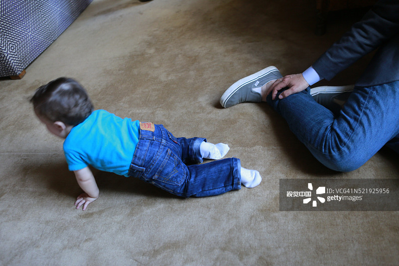 小男孩在父亲附近爬行图片素材
