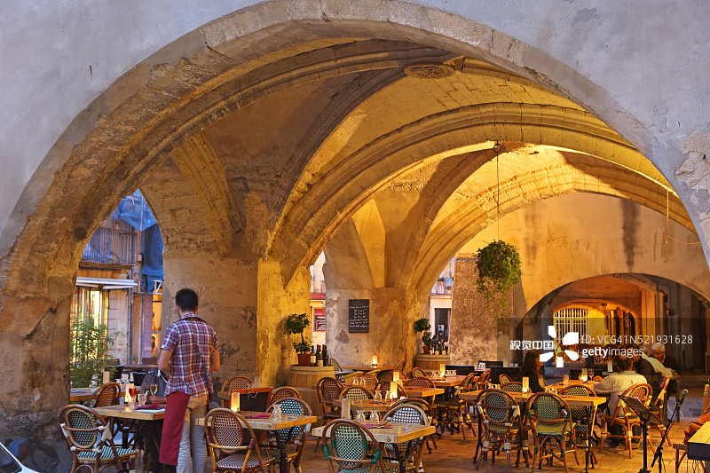 于泽Place Dampmartin拱廊下的餐厅，朗格多克-鲁西荣图片素材