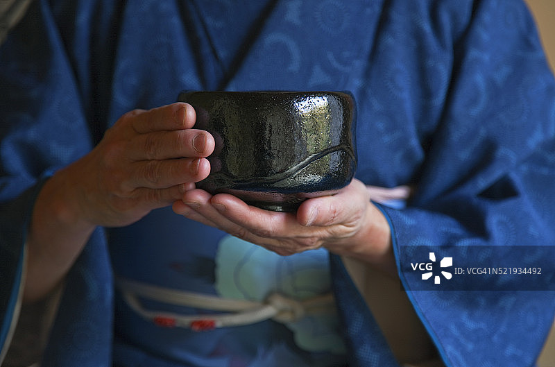 室内：穿和服的女子在茶室茶道中手持茶碗图片素材