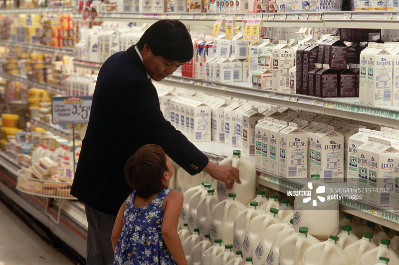 在食品杂货店里的女孩和父亲图片素材