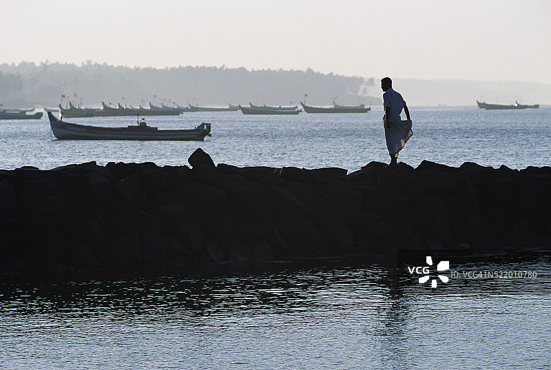男人站在防波堤上图片素材