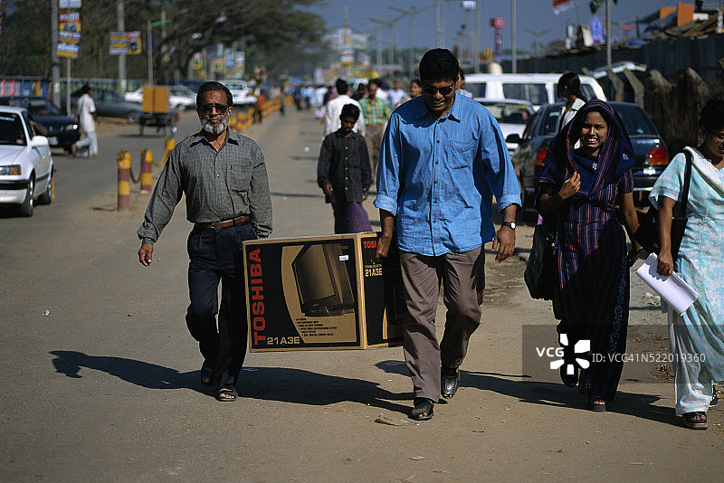 男人搬运箱装电视机图片素材