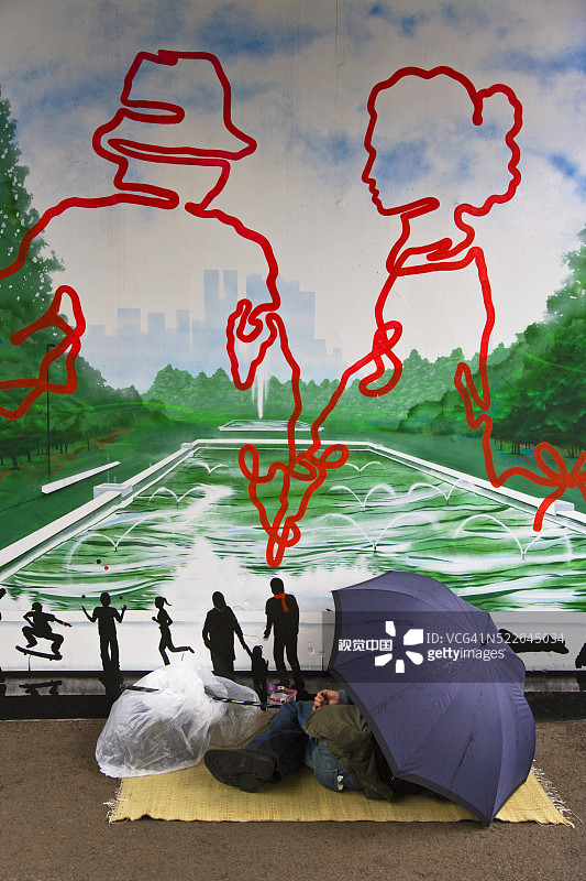 在壁画面前睡觉的流浪汉图片素材