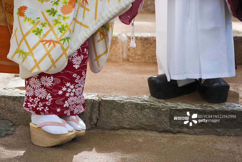 日本京都北野天满宫，舞妓和神道教祭司沿着纸屋川行走图片素材