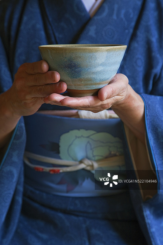 室内：穿和服的女子在茶室茶道中手持茶碗图片素材