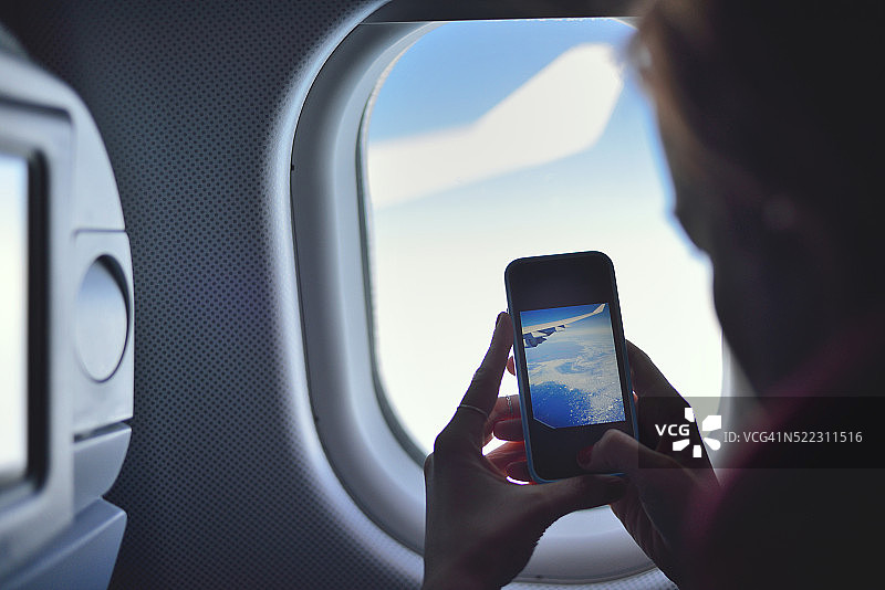 年轻女子在飞机上拍照图片素材