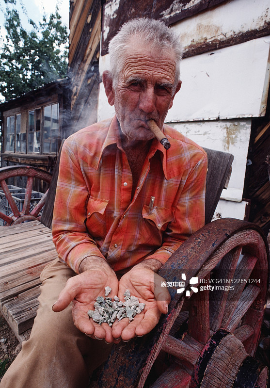 手持人造玻璃陨石样本的男人图片素材