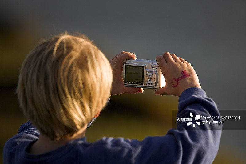 男孩用数码相机拍照图片素材