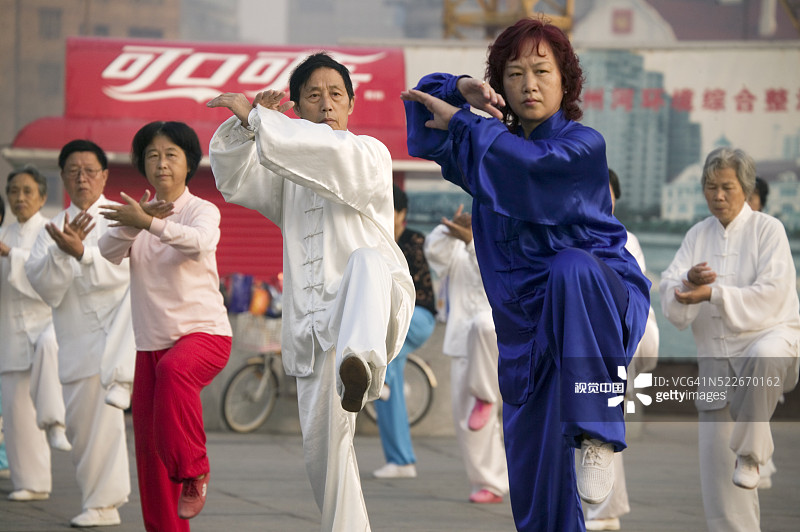 在广告牌前练习太极拳的群众图片素材