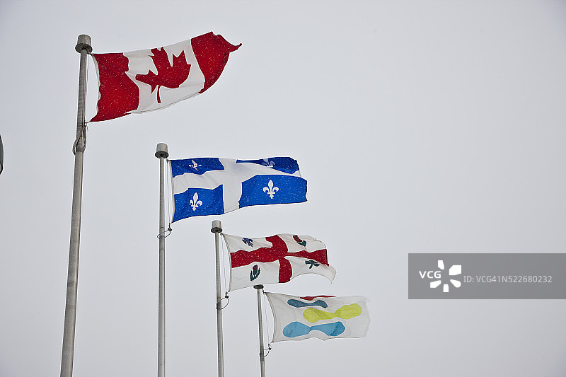迎风飘扬的加拿大、魁北克和蒙特利尔旗帜图片素材