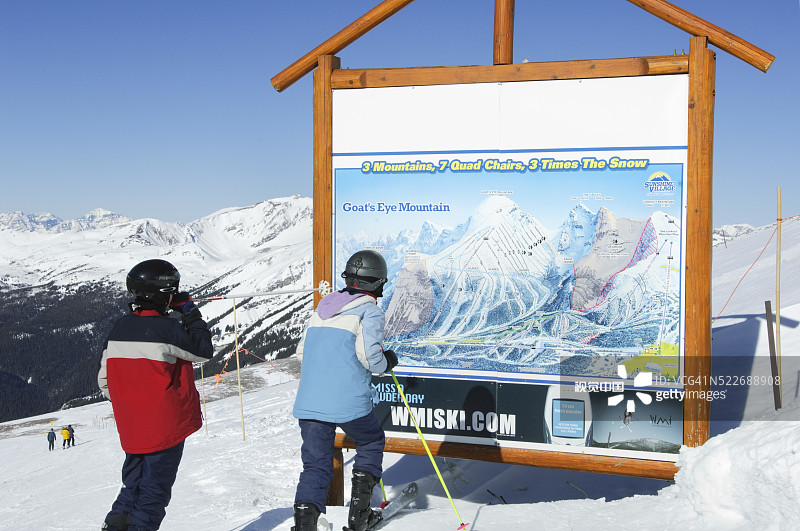 在加拿大班夫阳光村，滑雪者阅读滑雪区域地图图片素材