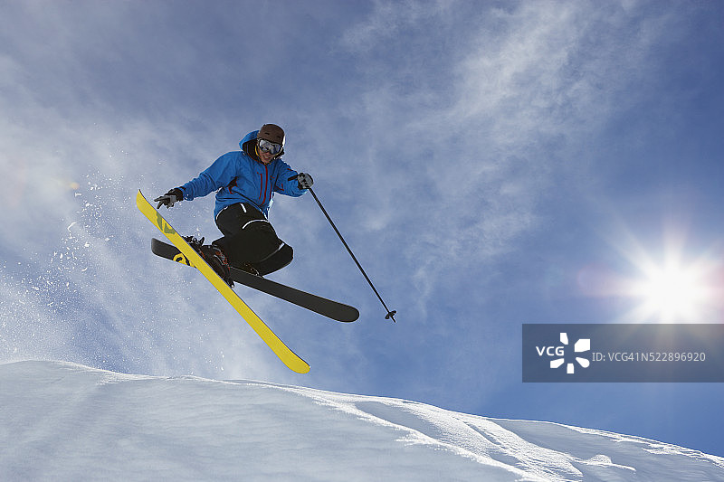 滑雪者从雪檐跳跃图片素材