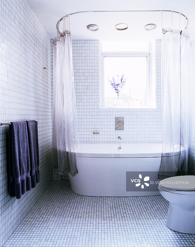 带白色浴缸的浅蓝色瓷砖浴室图片素材