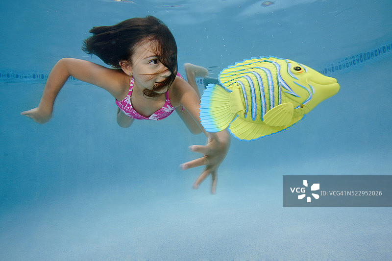 小女孩追逐玩具鱼图片素材