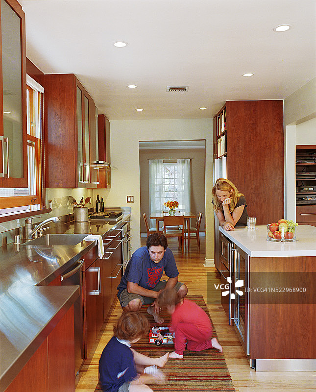 男孩在厨房玩耍，父母陪伴图片素材