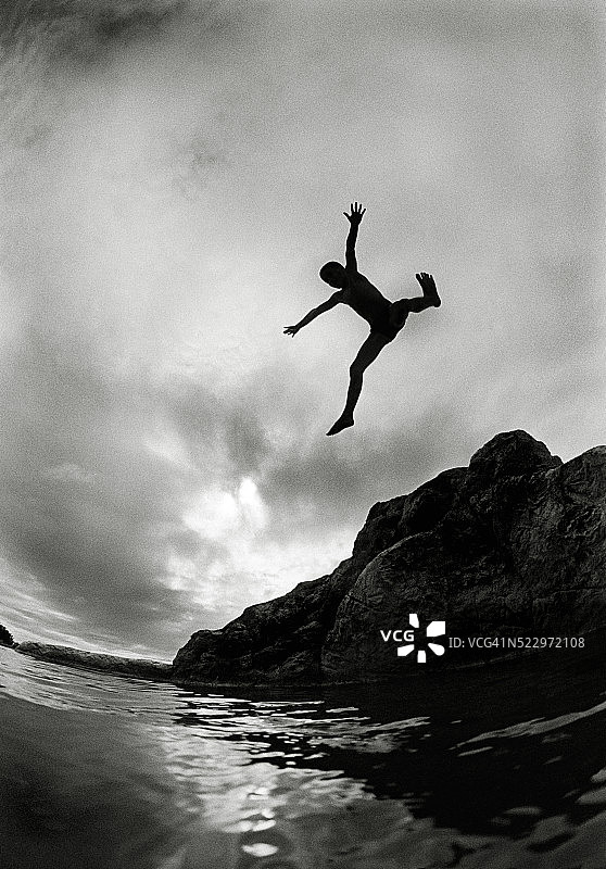 男孩从岩石上跳下图片素材
