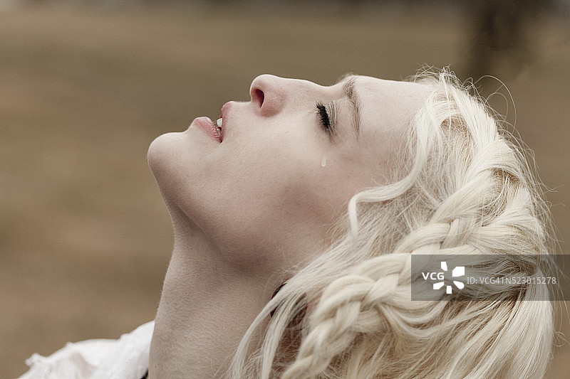 哭泣的年轻女人侧面照图片素材