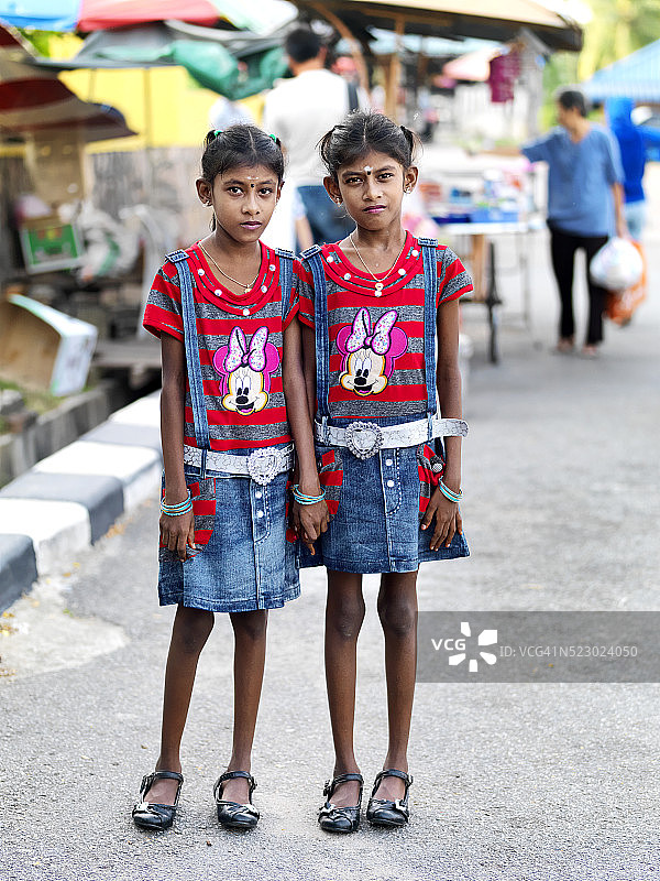 穿着相同服装的印度马来西亚双胞胎图片素材