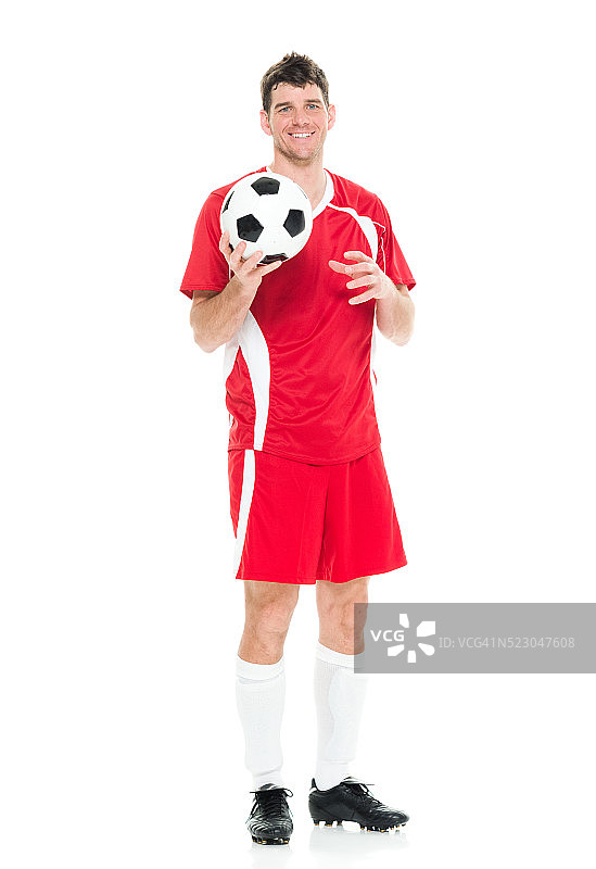 笑容满面的男足球运动员抱着球图片素材