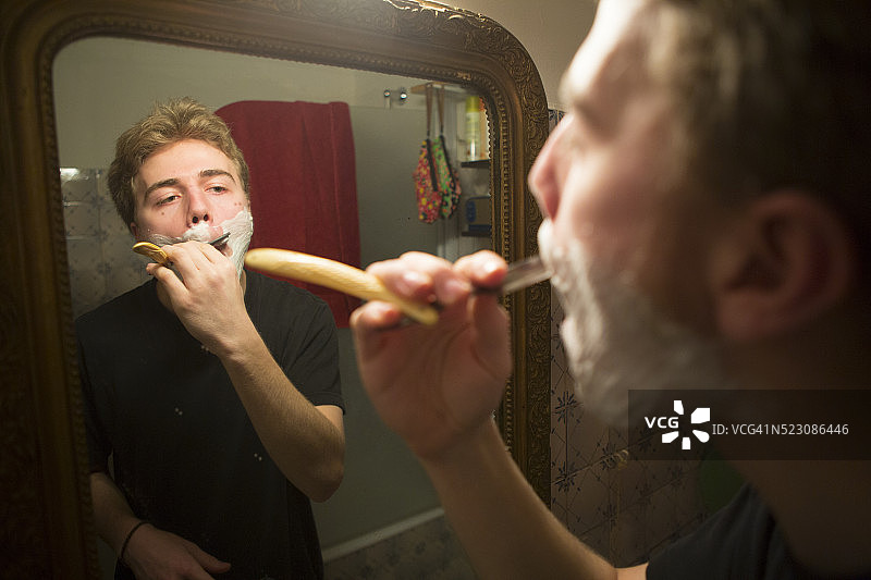 青年男子用直剃刀刮胡子图片素材