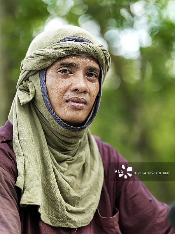 在丹绒比艾国家公园用摩托车拖运设备的工人图片素材