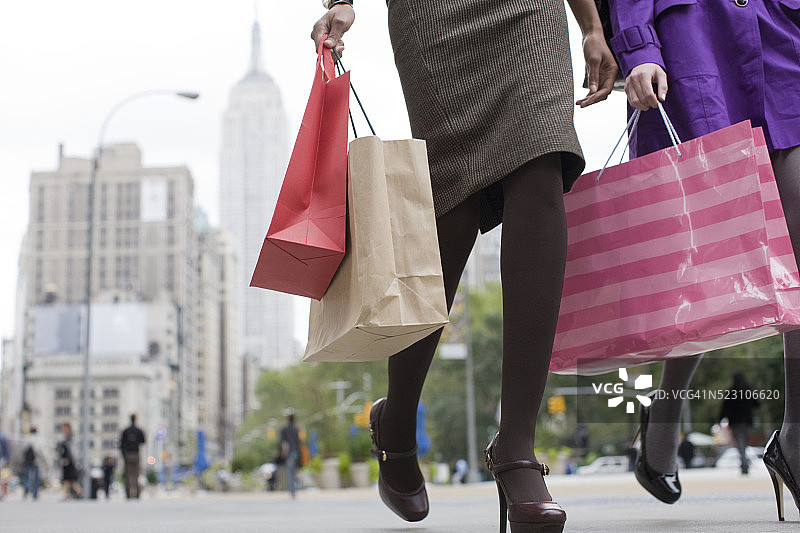 提着购物袋在城市的年轻女性图片素材