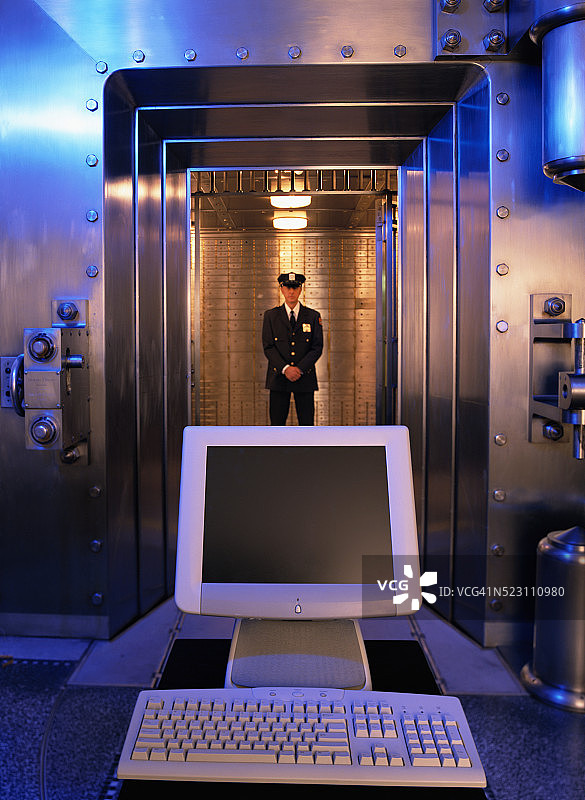 银行警卫和金库前的电脑图片素材